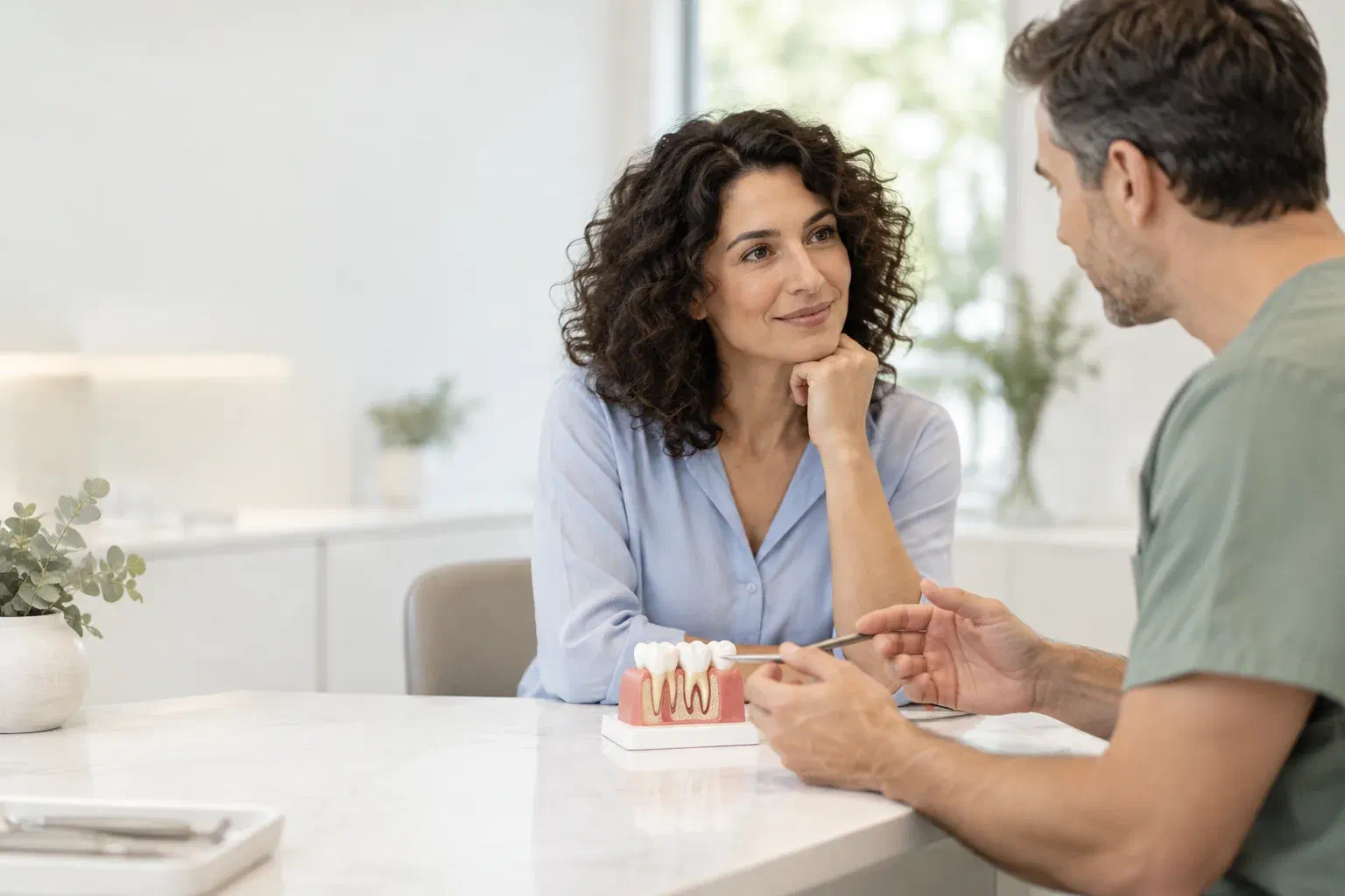 Illustrative patient discussing gum health with a clinician and a small dental model
